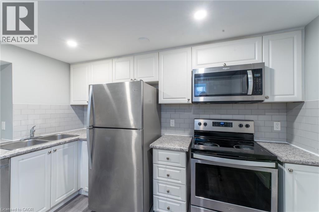 A kitchen with white cabinets and stainless steel appliances.