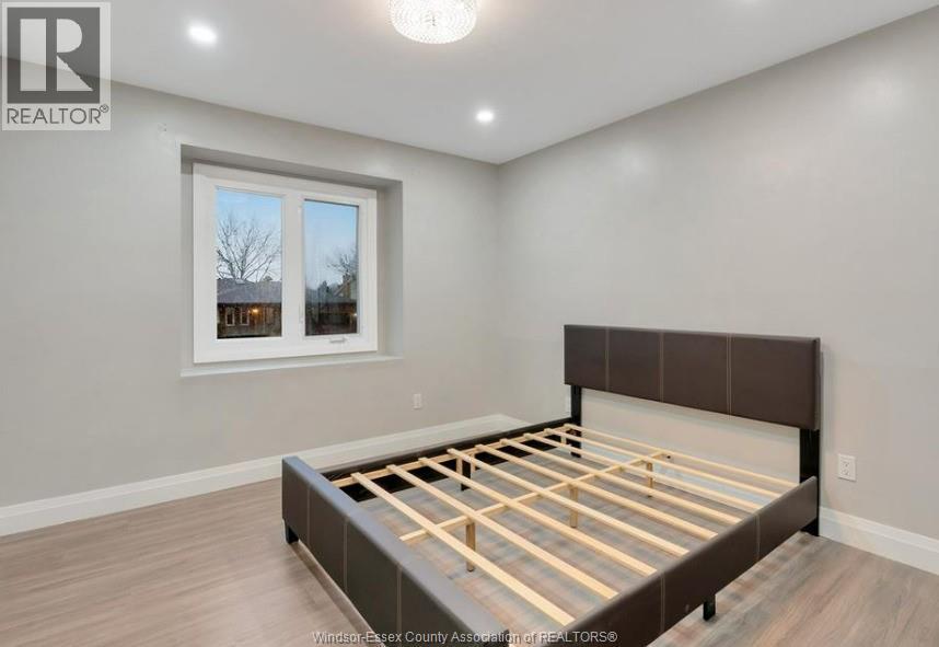 A bedroom with a bed frame in the middle of the room.