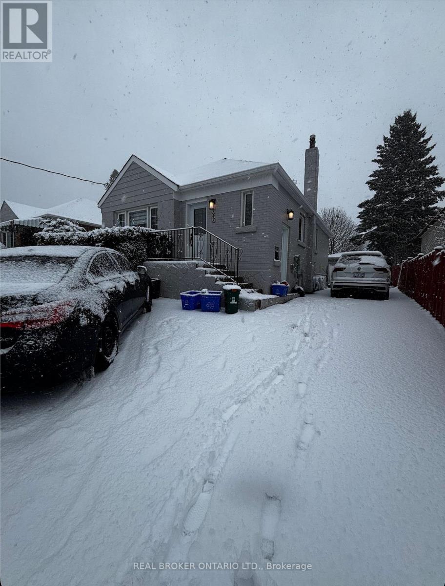 A snow-covered street with a house and cars on the side.