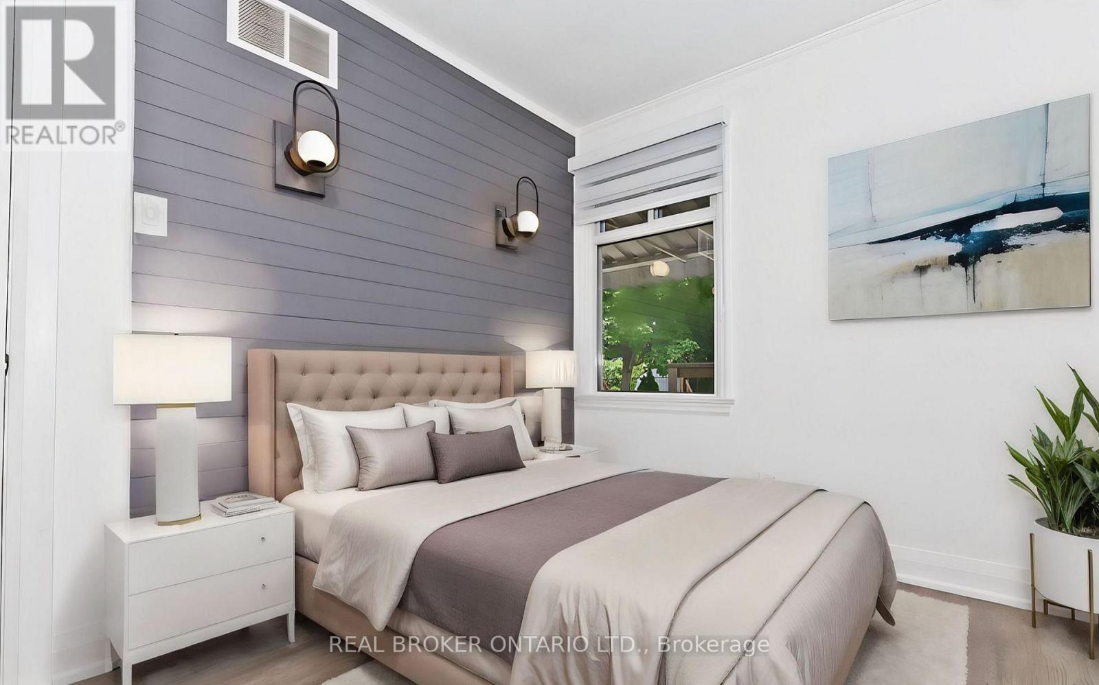 A bedroom with a bed, nightstand, and a painting on the wall.