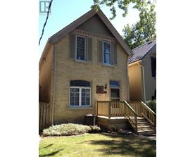 A house with a brown brick exterior and a wooden porch.