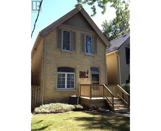 A house with a brown brick exterior and a wooden porch.