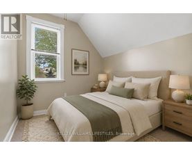 A bedroom with a bed, nightstands, and a window.