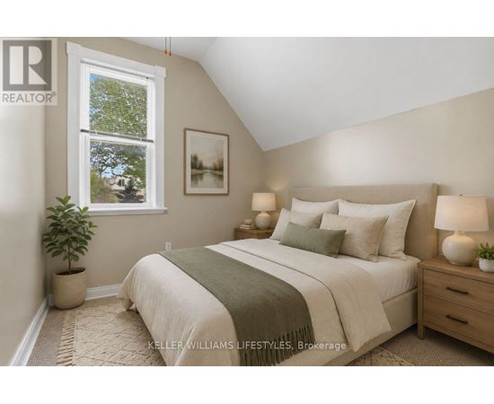 A bedroom with a bed, nightstands, and a window.