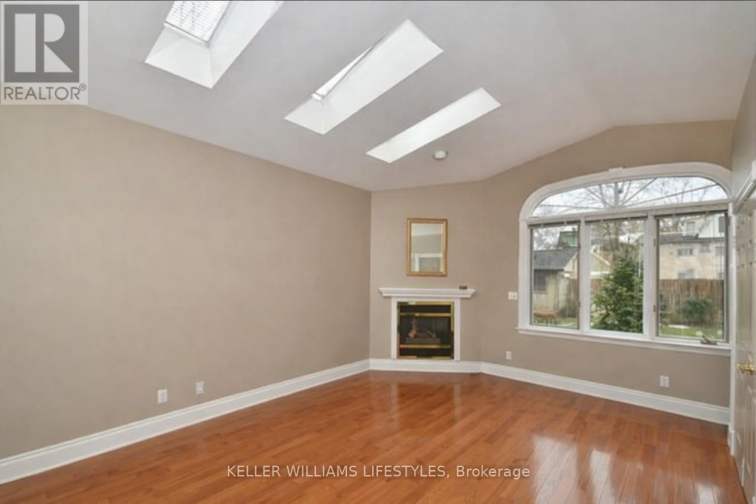 A spacious room with a fireplace and skylights.