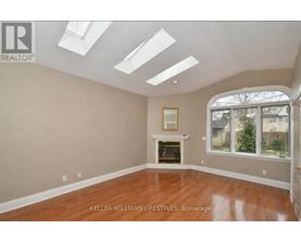 A spacious room with a fireplace and skylights.