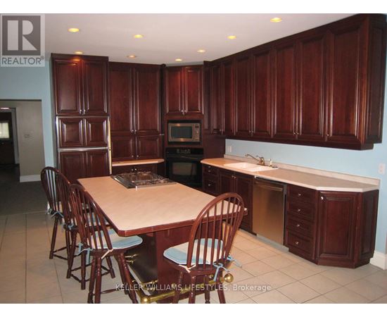 A kitchen with wooden cabinets and a table with chairs.