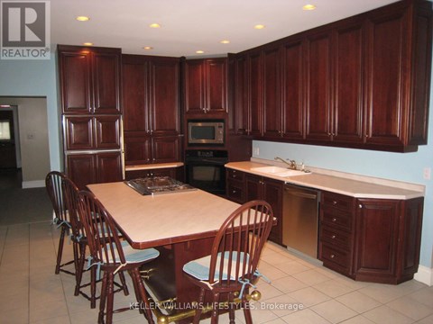 A kitchen with wooden cabinets and a table with chairs.
