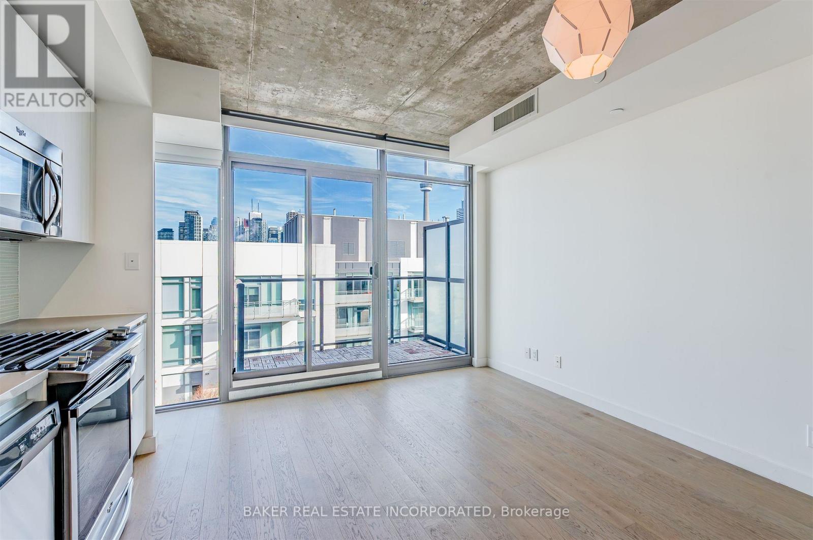 A spacious room with a view of the city through large windows.