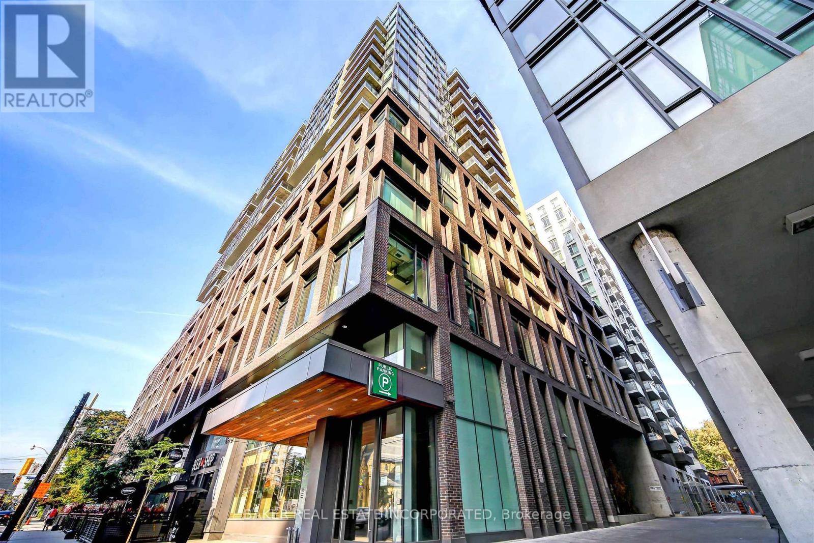 A tall, modern building with a wooden facade stands prominently in the foreground.