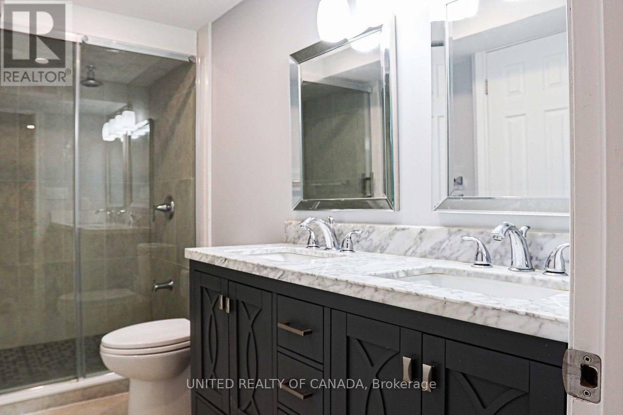 A bathroom with a marble countertop and a walk-in shower.