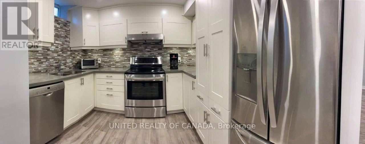A modern kitchen with stainless steel appliances and white cabinets.