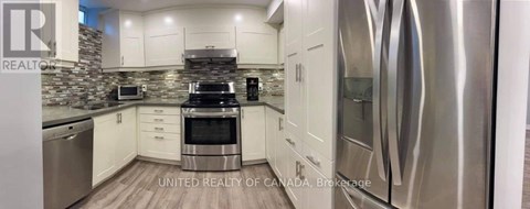 A modern kitchen with stainless steel appliances and white cabinets.