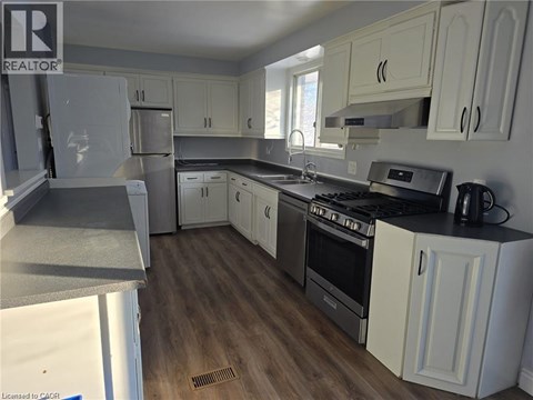 A kitchen with white cabinets and a black stove top.
