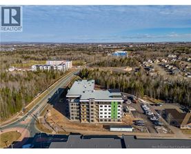 A real estate board logo is visible on an aerial image of a building complex.