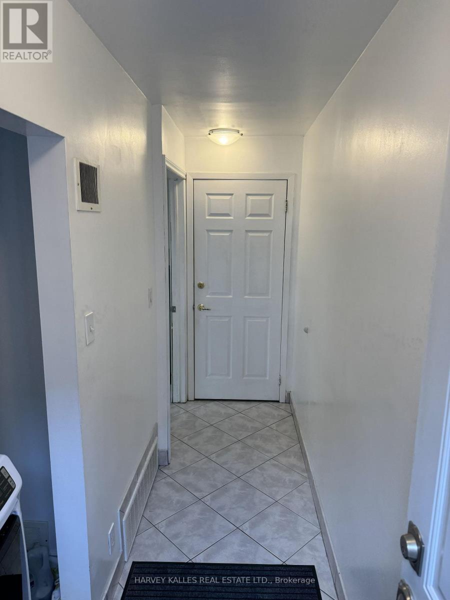 A hallway with a brokerage sign on the floor.