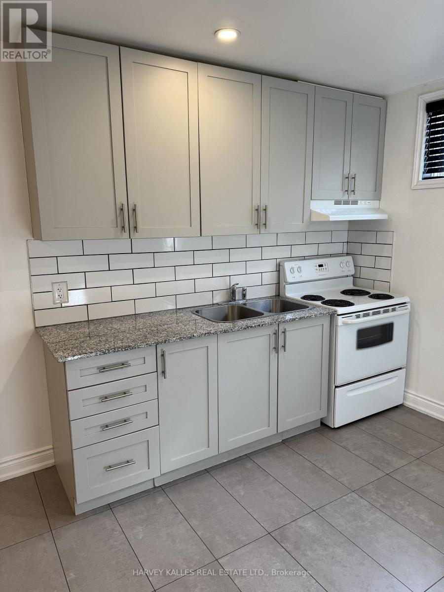 A kitchen with white cabinets and a white stove top oven.