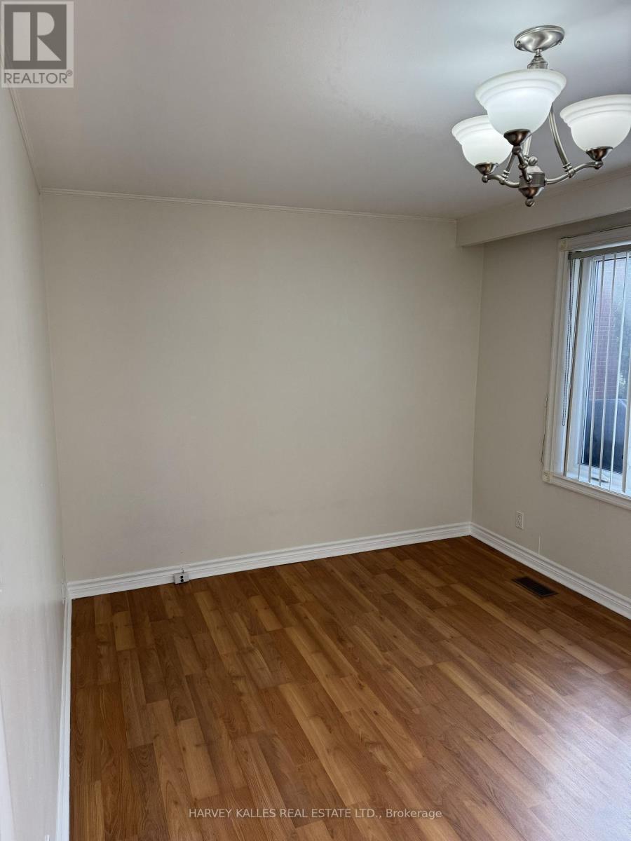 A room with wooden flooring and a chandelier.
