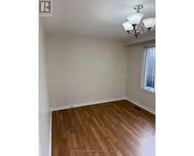 A room with wooden flooring and a chandelier.