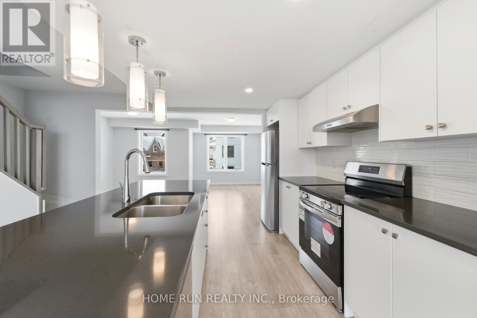 A modern kitchen with white cabinets and stainless steel appliances.