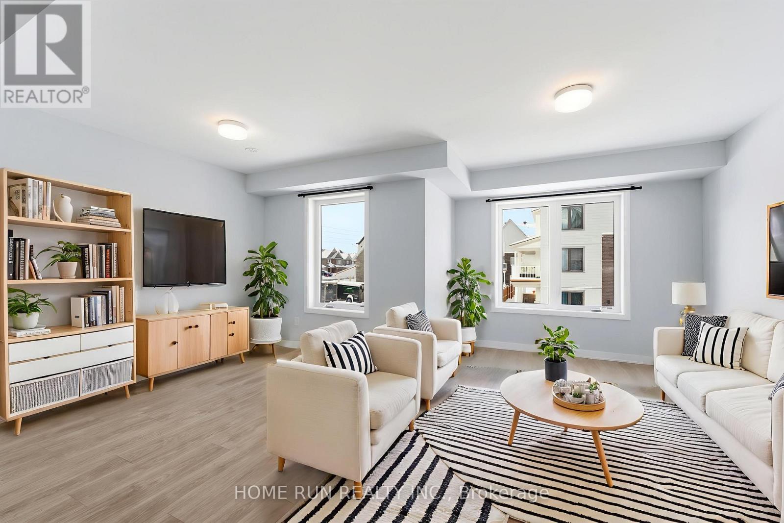 A living room with a white couch, a coffee table, and a television.