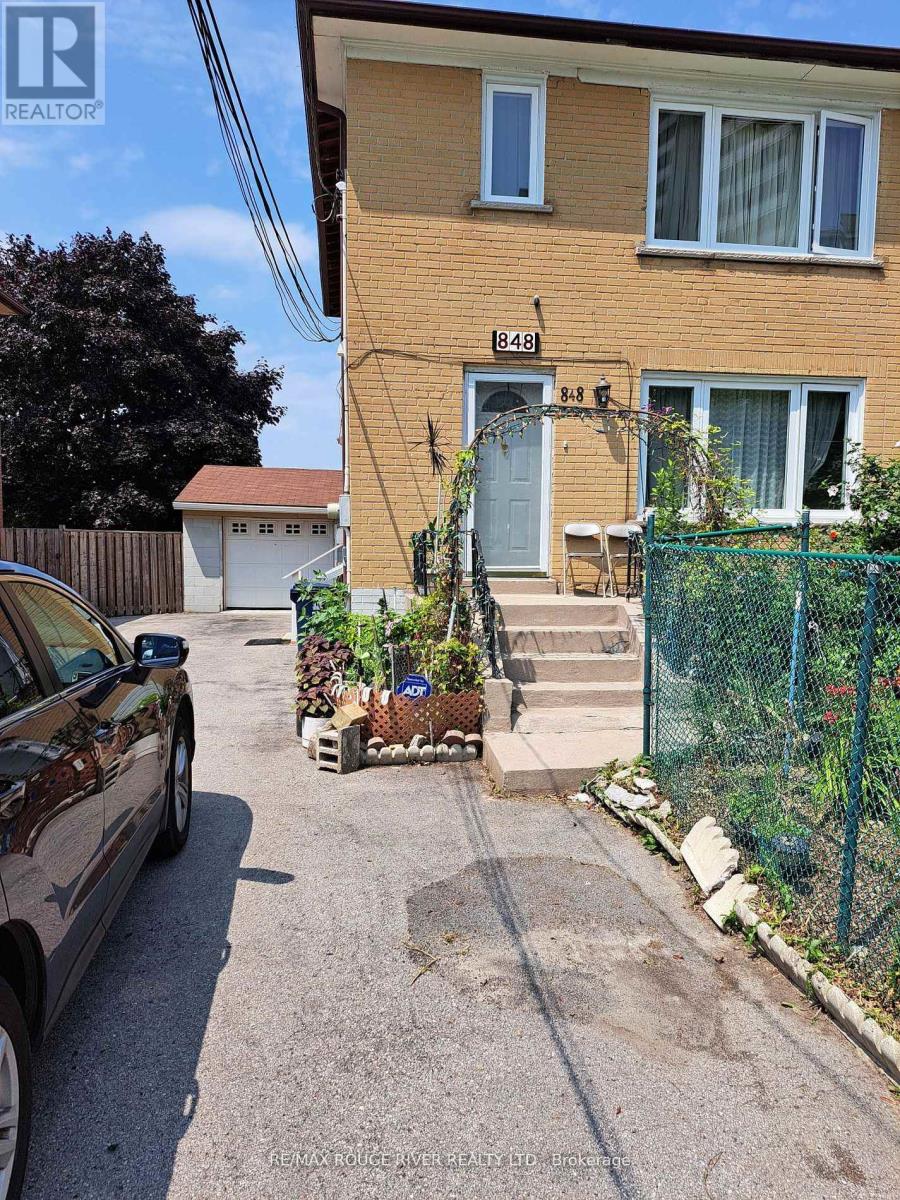 A brown house with a car parked in front of it.