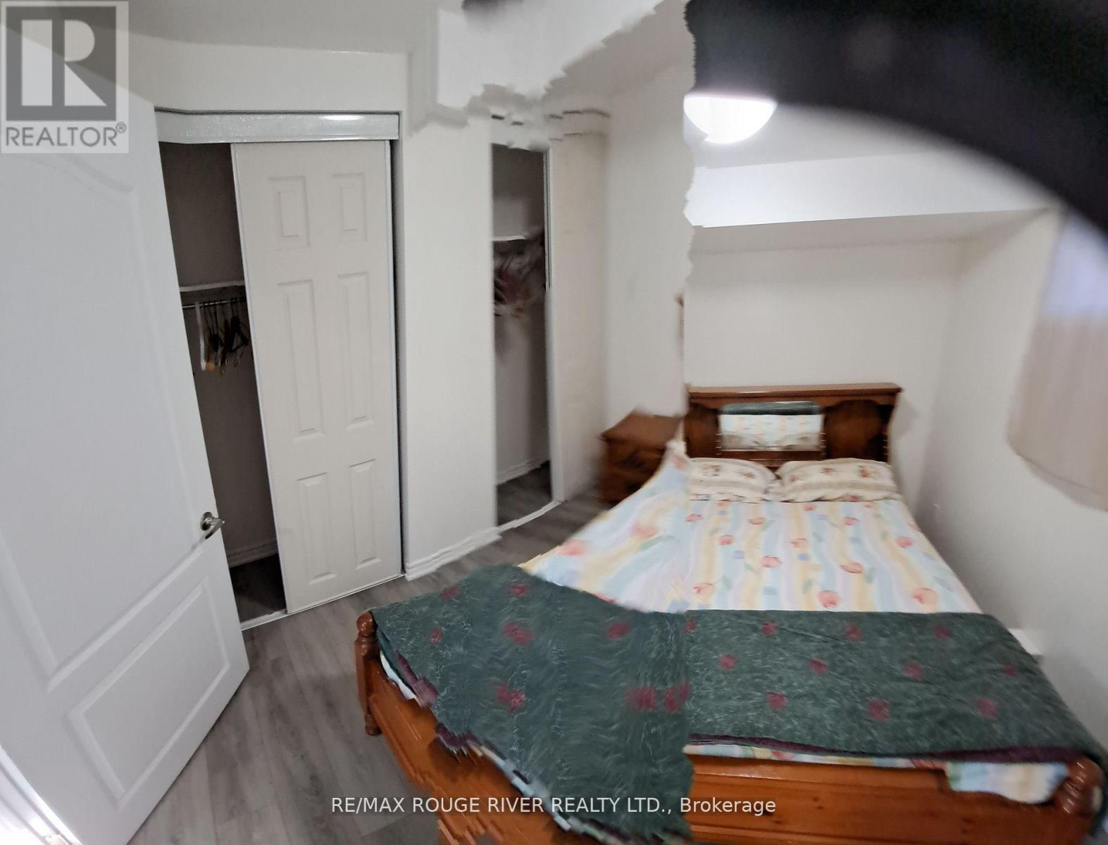 A bedroom with a bed, dresser, and closet.