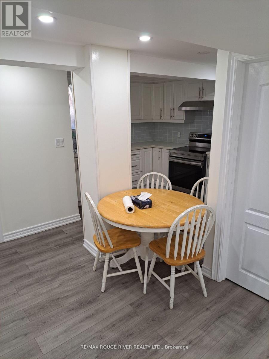 A dining room with a round table and chairs.