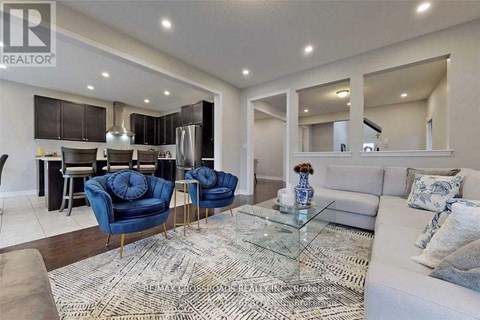 A modern living room with a glass coffee table and blue chairs.