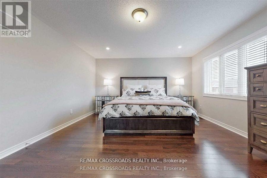 A bedroom with a large bed and wooden floors.