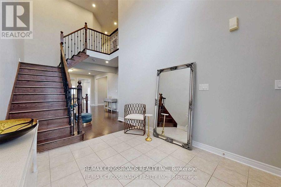 A spacious room with a staircase and a large mirror.