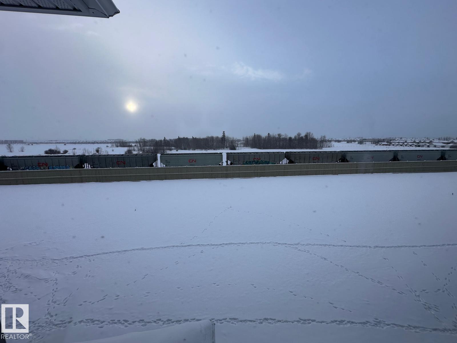 A snowy landscape with a building in the distance.