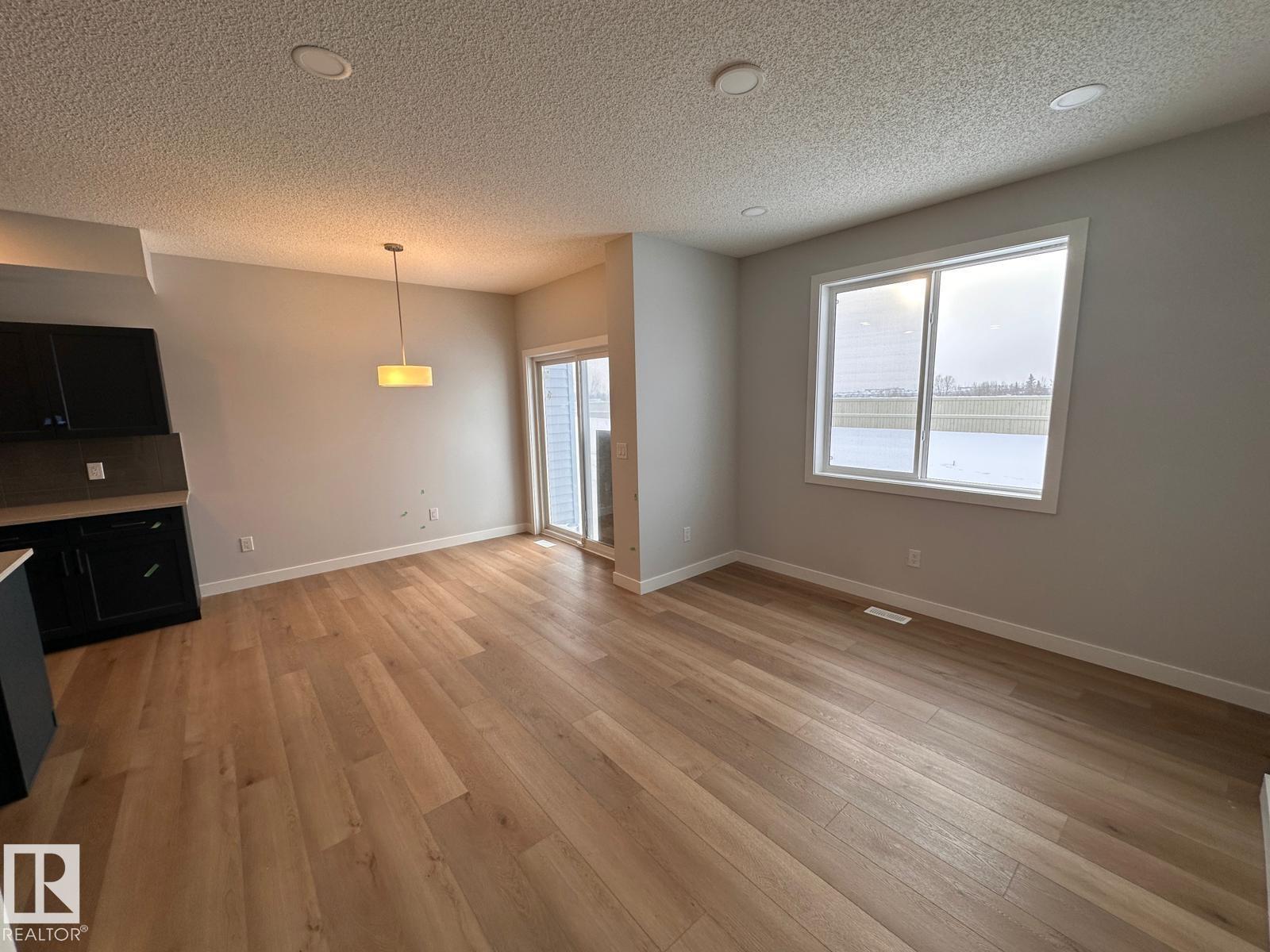 A room with wooden flooring and a large window.