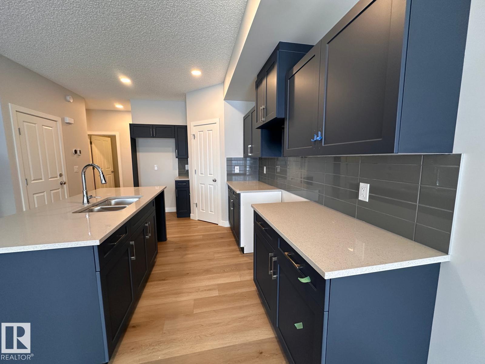 A kitchen with dark blue cabinets and a white countertop.