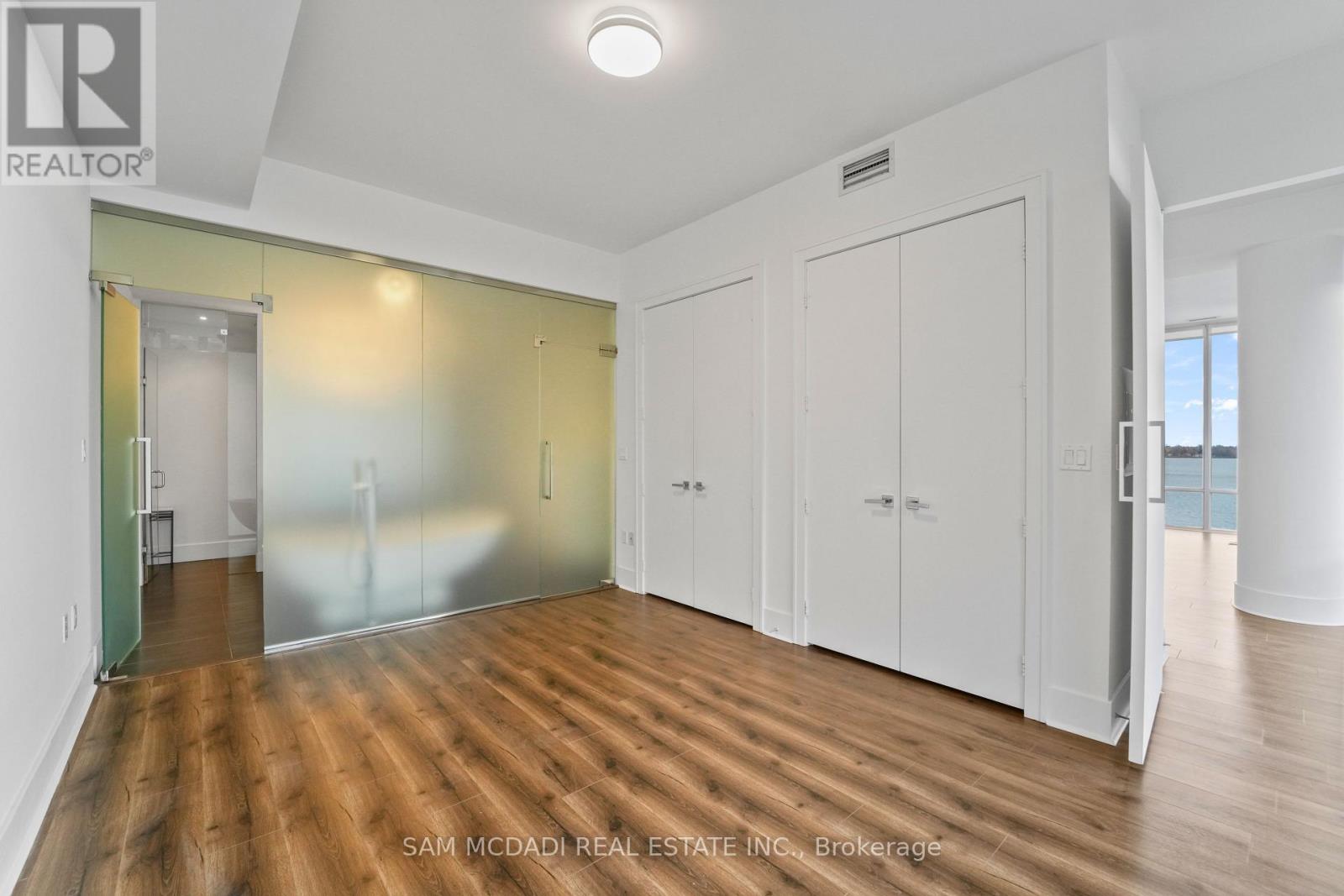 A room with wood flooring and white walls.