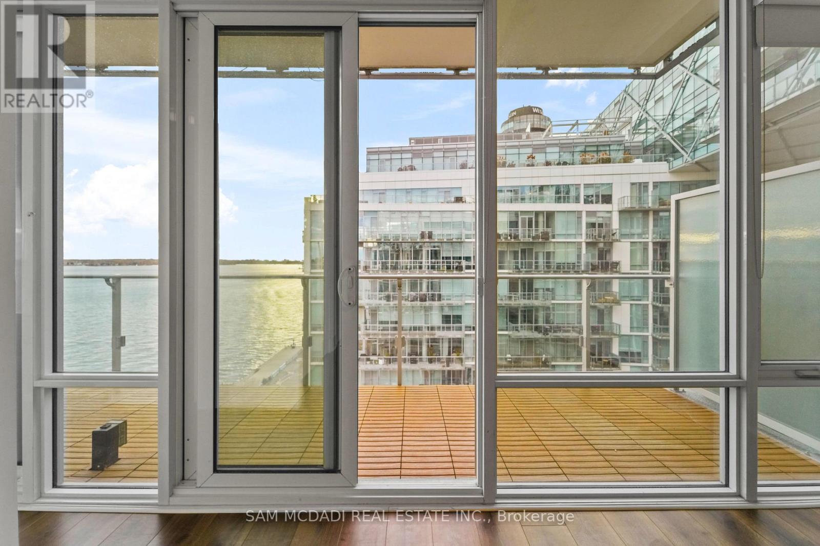 A view from a room looking out to a balcony and a building.