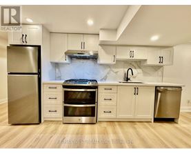 A kitchen with a refrigerator, oven, and cabinets.