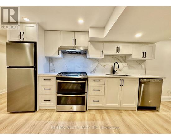 A kitchen with a refrigerator, oven, and cabinets.