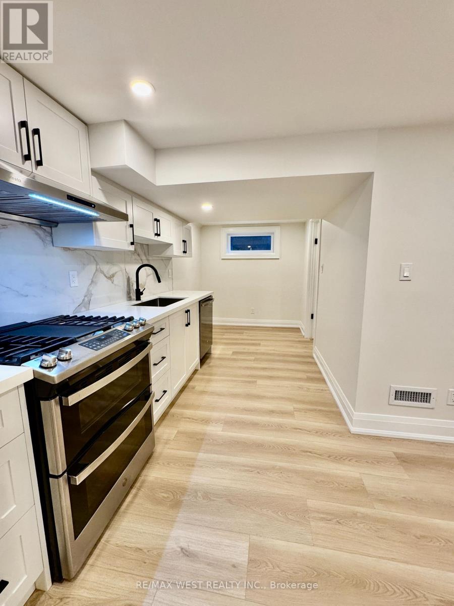 A kitchen with a stove top oven and a range hood.