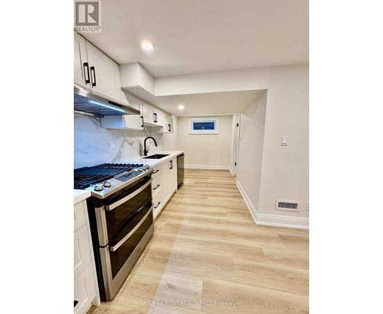 A kitchen with a stove top oven and a range hood.
