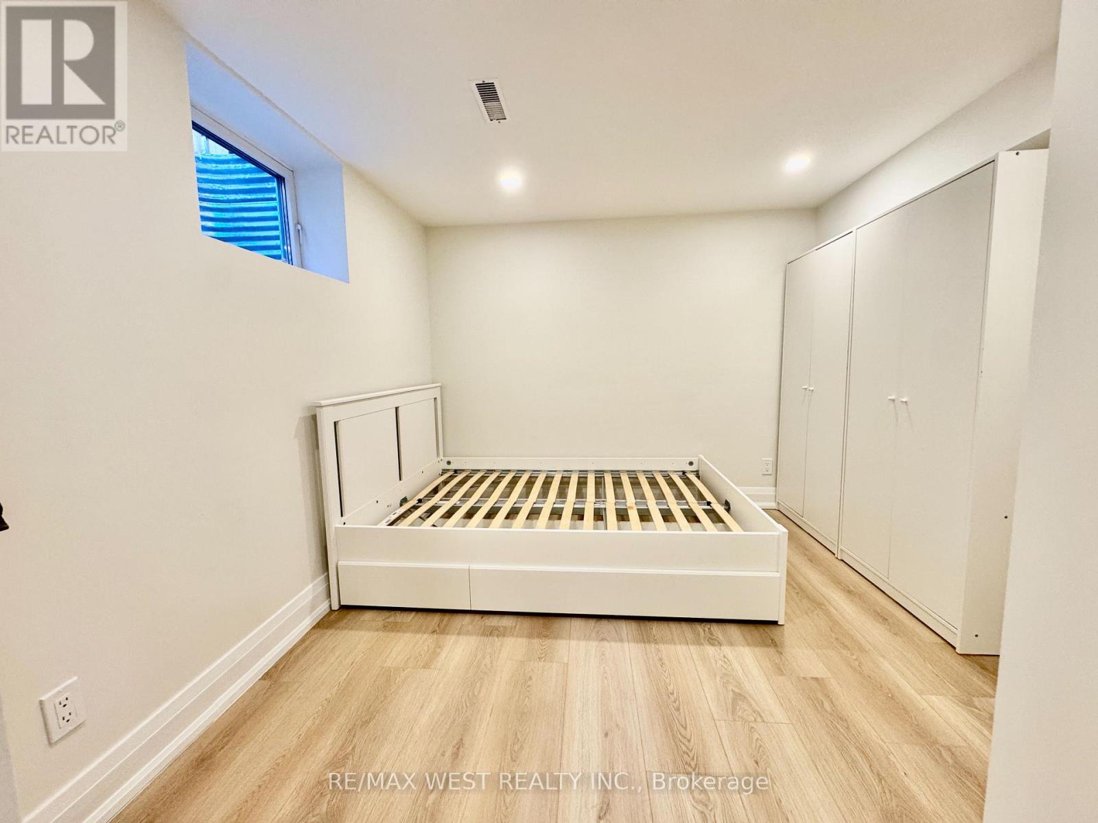 A bedroom with a bed, wardrobe and window.