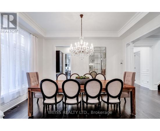 A dining room with a wooden table and chairs.