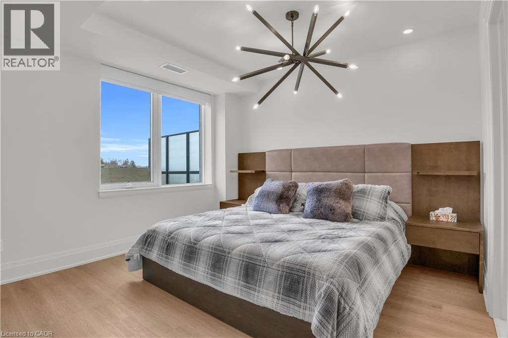A bedroom with a bed, a bench, and a window overlooking the ocean.