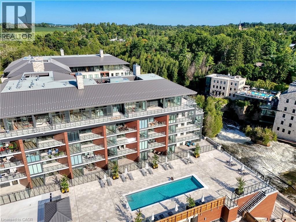 A large apartment complex with a pool in the middle of a courtyard.