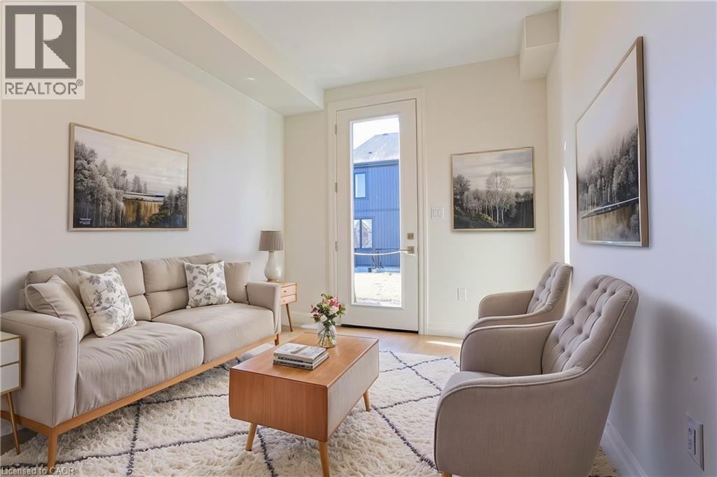 A living room with a couch, chair, and pictures on the wall.