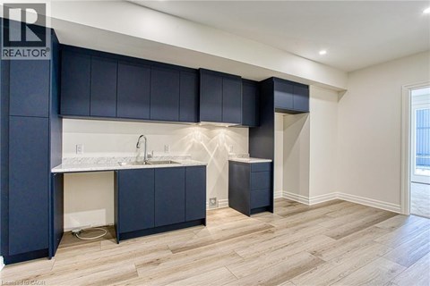 A modern kitchen with dark blue cabinets and a white countertop.