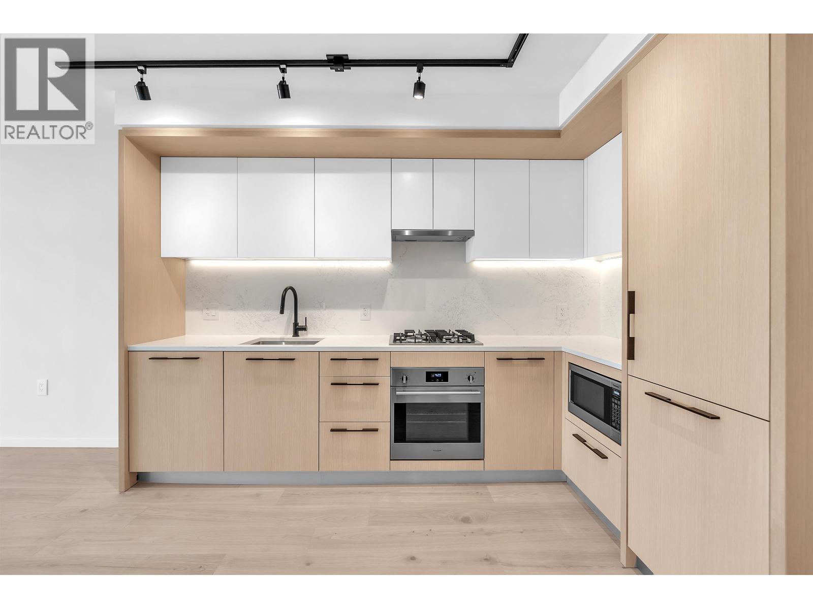 A modern kitchen with wooden cabinets and stainless steel appliances.