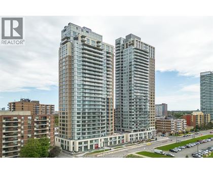 A tall building with many windows is the main focus of this image.