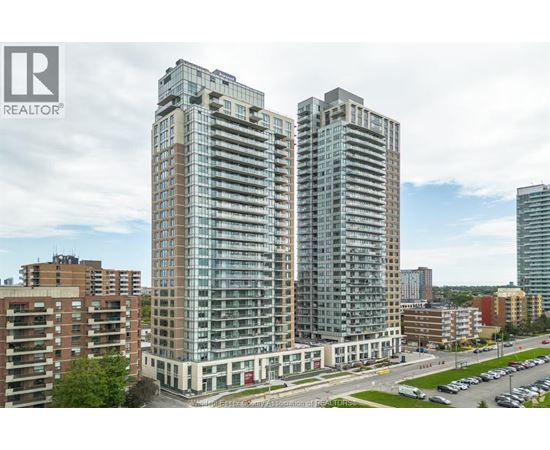 A tall building with many windows is the main focus of this image.