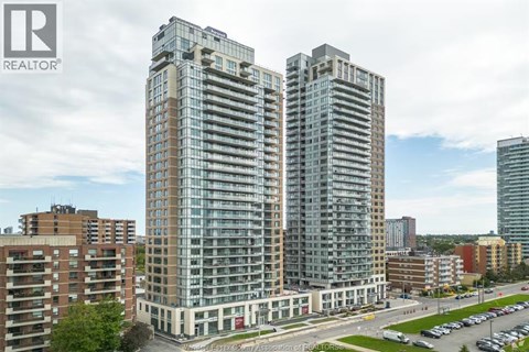 A tall building with many windows is the main focus of this image.